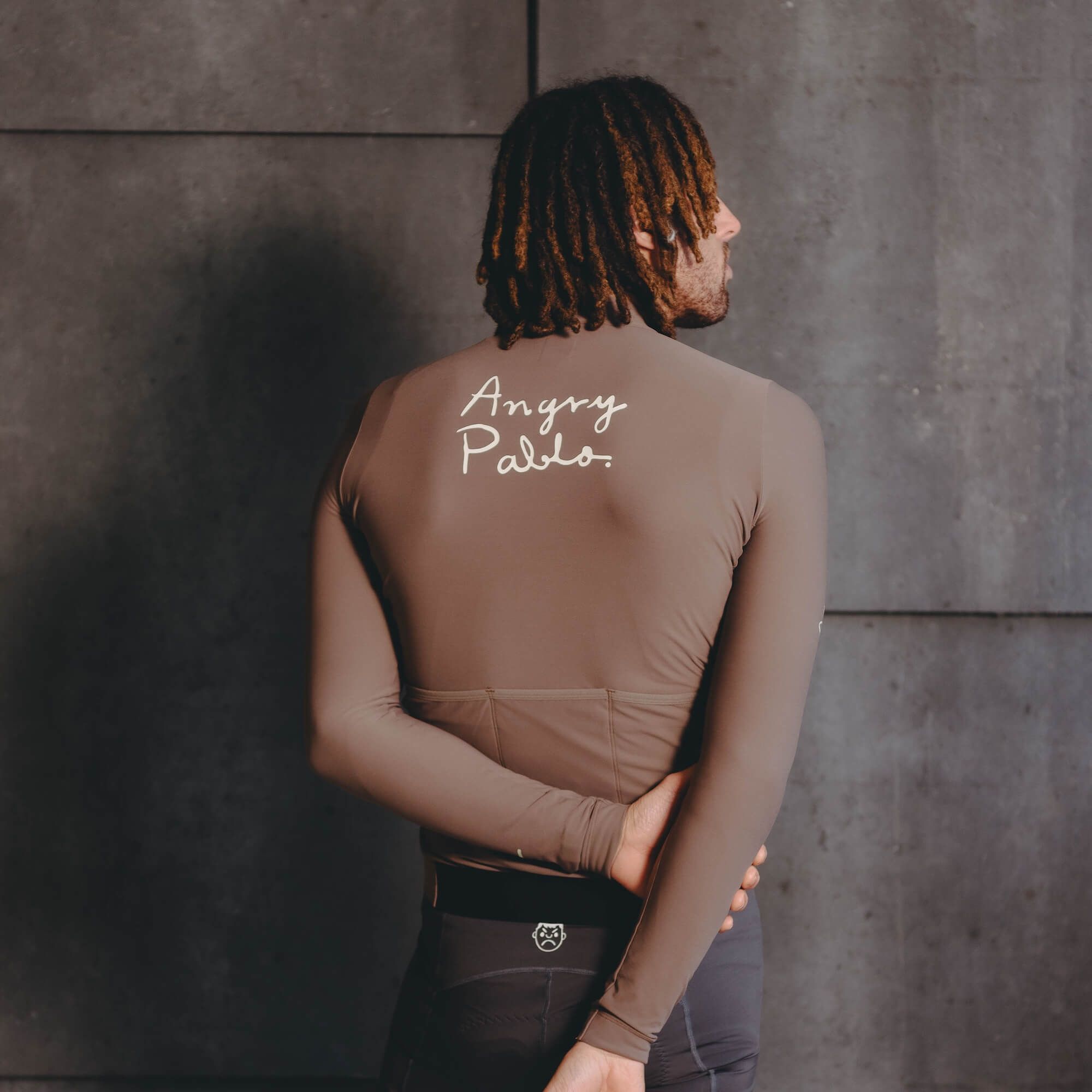 A male model wearing a brown Angry Pablo long sleeve cycling jersey